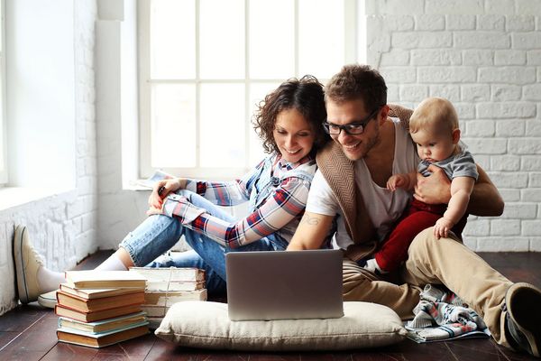 Young happy family relaxing at home on the floor