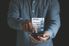 Email hack, System hacked warning alert, SMS spam, and fake text message phishing concept. scam malware spreading virus on messages alert virtual on mobile smart phone screen in businessman's hand.